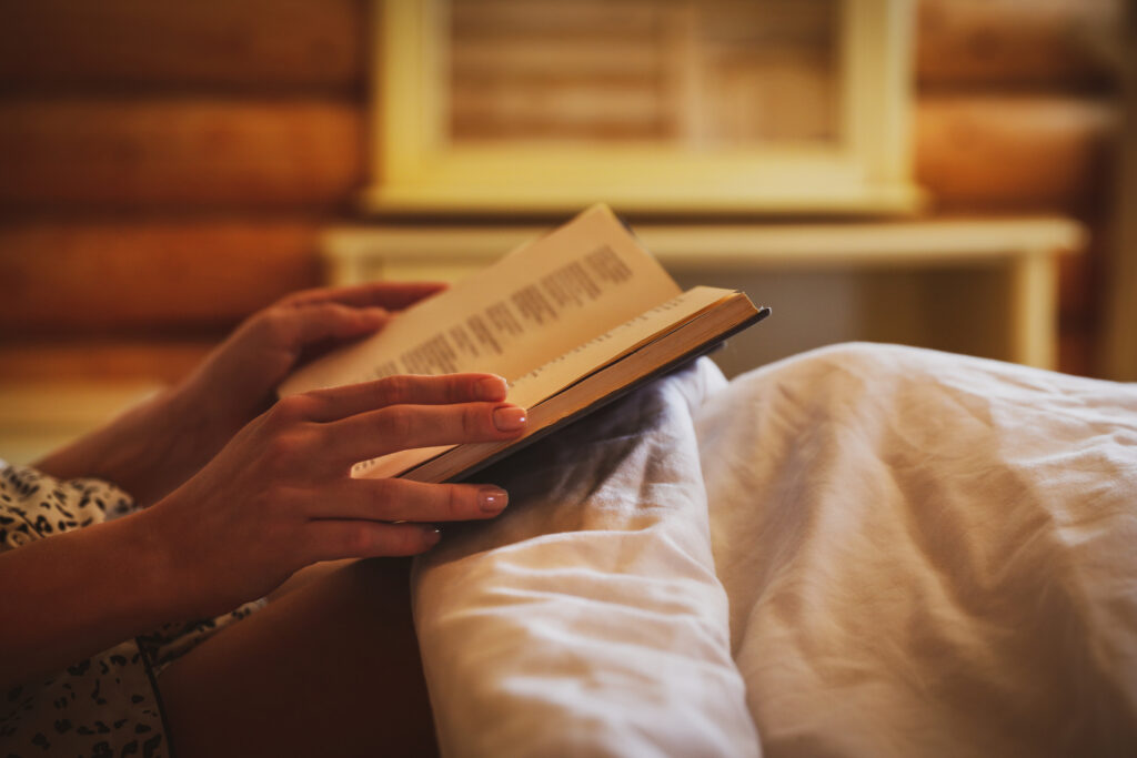 Frau liest Buch im Bett