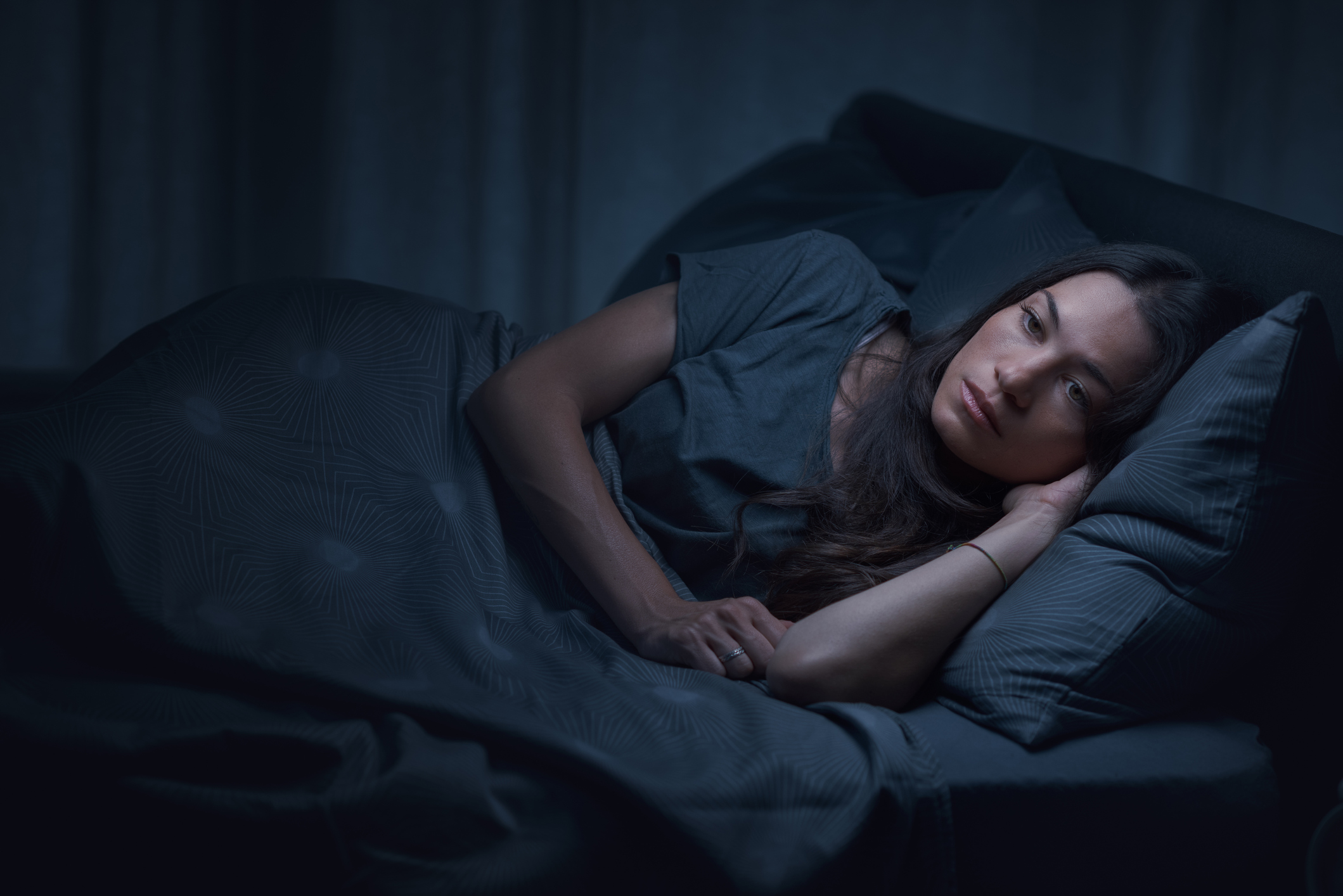 Frau liegt Wach im Bett