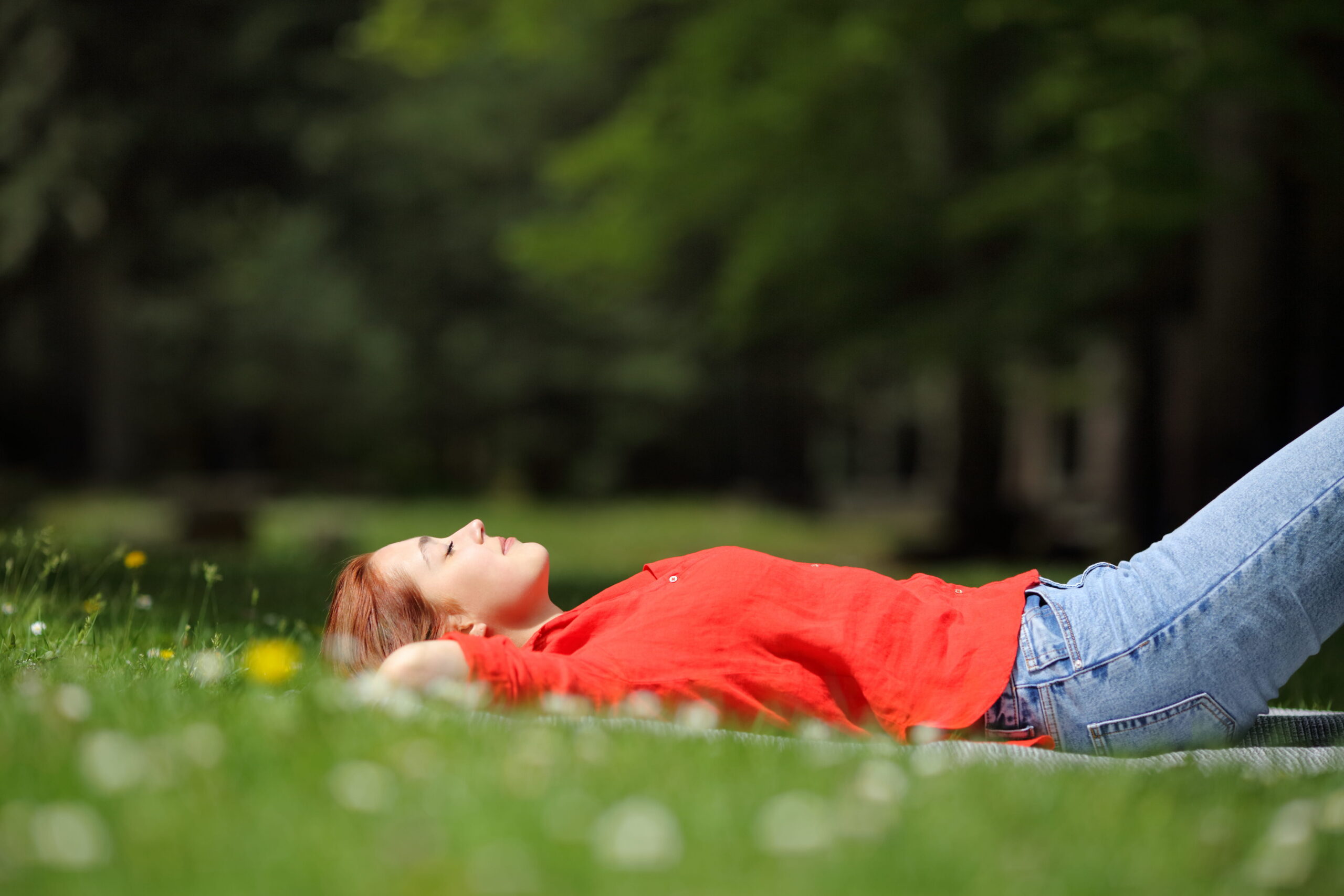 Frau liegt im Gras schlafend